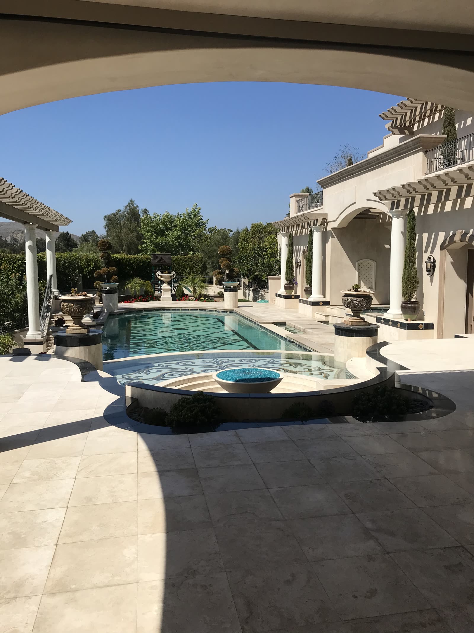 Pool, spa and fire bowl framed by columns and pergolas