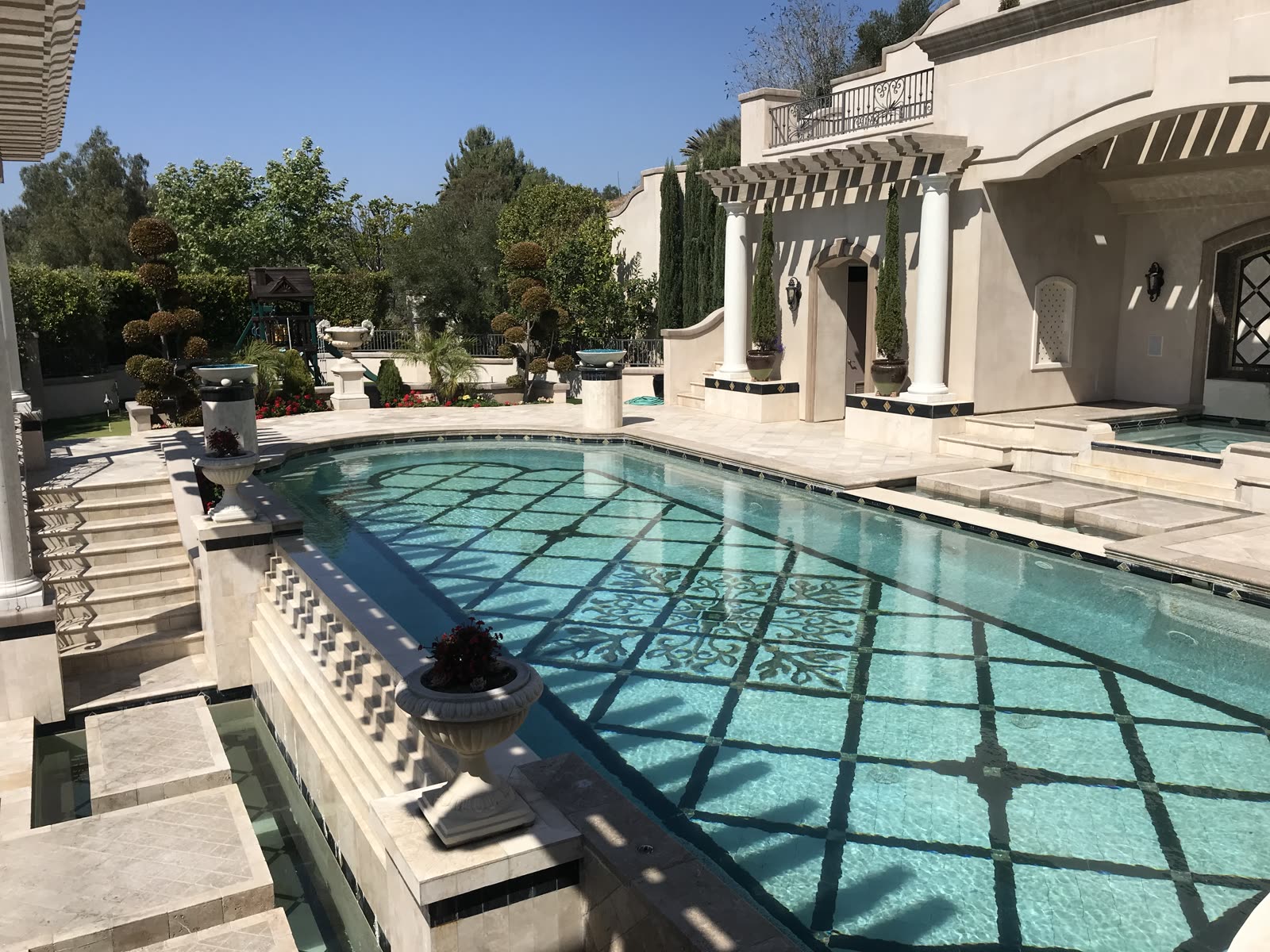 Estate pool with mosaic tile inlay and classical colonnade